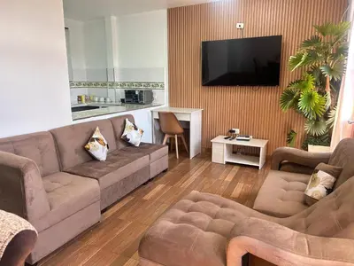 a living room with a couch and a flat screen tv at Departamentos Sumaq Plaza II in Ayacucho