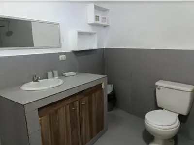 a bathroom with a white toilet and a sink at Casa En Asia in San Antonio