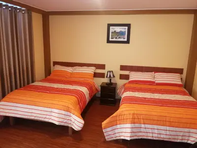 two beds sitting next to each other in a bedroom at Nasca Travel One Hostel in Nazca