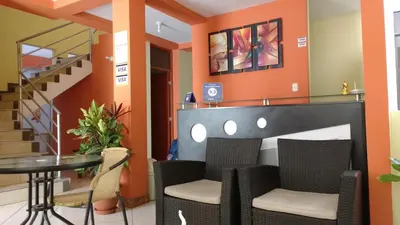 a dining room with orange walls and a table and chairs at Nasca Travel One Hostel in Nazca