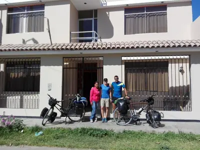 a group of three people standing in front of a house at Nasca Travel One Hostel in Nazca