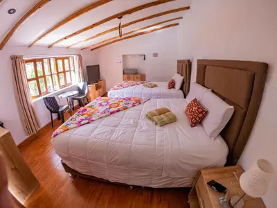 a bedroom with two large beds in a room at Kay Pacha Wellness Place Eco in Ayacucho