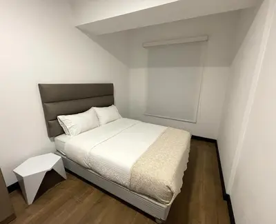a small bedroom with a white bed and a table at 2 Bedroom Apartments San Isidro Business Zone in Lima