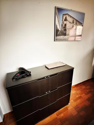 a black dresser against a wall with a phone on it at Mini Apartamento BARRANCO in Lima