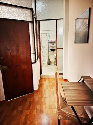 a dining room with a table and a wooden door at Mini Apartamento BARRANCO in Lima