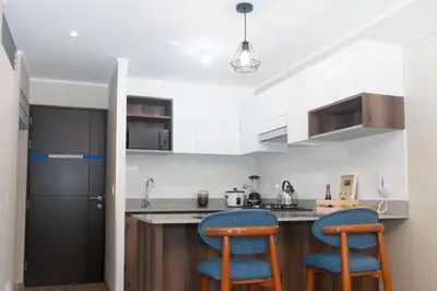 a kitchen with two blue bar stools at Estilo y comodidad in Lima