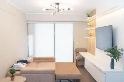 a living room with a couch and a tv at Estilo y comodidad in Lima
