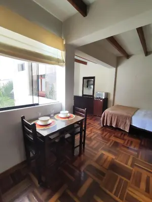 a room with a table and chairs and a bed at Amplia habitación independiente Larcomar in Lima