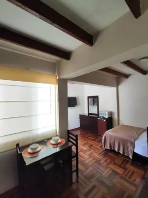 a room with a bed and a table with plates on it at Amplia habitación independiente Larcomar in Lima