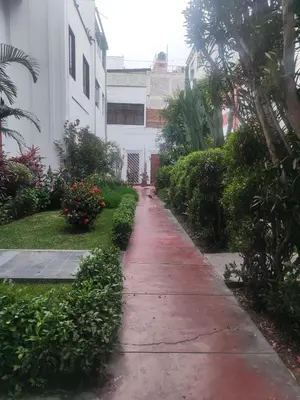 a wet sidewalk in front of a building at Amplia habitación independiente Larcomar in Lima