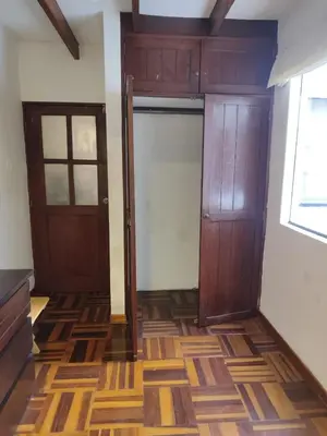 an empty room with two doors and wooden floors at Amplia habitación independiente Larcomar in Lima