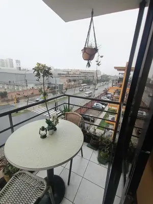 a table on a balcony with a view of a city at Habitación acogedora amoblada in Lima