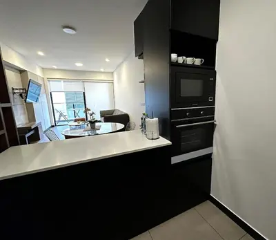 a kitchen with a counter and a sink and a microwave at 1 Bedroom Apartment San Isidro Business Zone in Lima