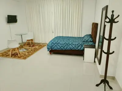 a bedroom with a bed and a table in it at Monoambiente de estreno 35 m2 in Lima