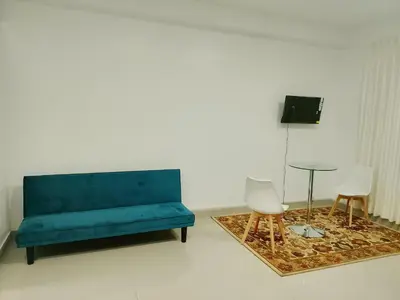 a blue couch in a room with a table and chairs at Monoambiente de estreno 35 m2 in Lima