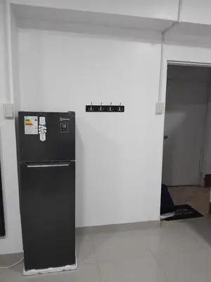 a black refrigerator in a room with a white wall at Monoambiente de estreno 35 m2 in Lima