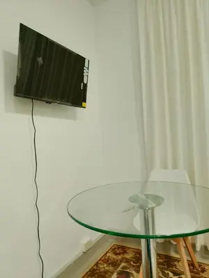 a glass table with a television on a wall at Monoambiente de estreno 35 m2 in Lima