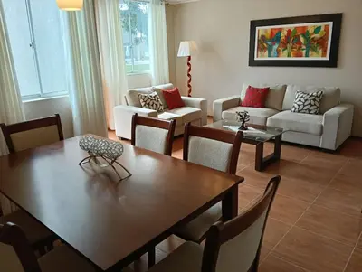 a living room with a table and a couch at Casita en Ica con piscina in Ica