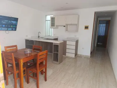 a kitchen with a wooden table and wooden chairs at Casa Hamuys - Ica in Ica