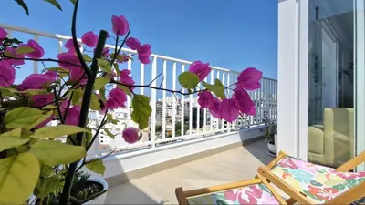 a balcony with pink flowers and a chair at Beautiful Duplex in the Heart of Miraflores in Lima