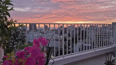 a view of a city from a balcony with pink flowers at Beautiful Duplex in the Heart of Miraflores in Lima