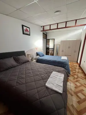 a bedroom with two beds and a couch at Allyu Wasi-Chanka in Andahuaylas