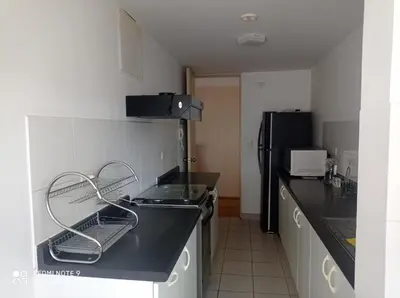 a kitchen with a black counter top and a refrigerator at Cozy Furnished Brand New Apartment