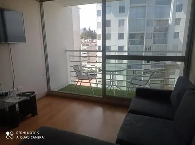 a living room with a couch and a balcony with a table at Cozy Furnished Brand New Apartment