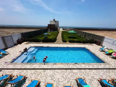 a swimming pool with two people in the water at RELAX Y PISCINA con vista al MAR - FLAT in Cerro Azul