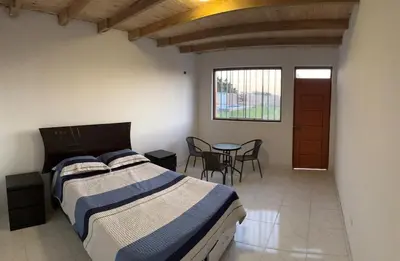 a bedroom with a bed and a table with chairs at Casa de campo relax y piscina in Cerro Azul