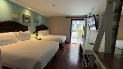 a hotel room with two beds and a television at La Casa del Viajero in Lima