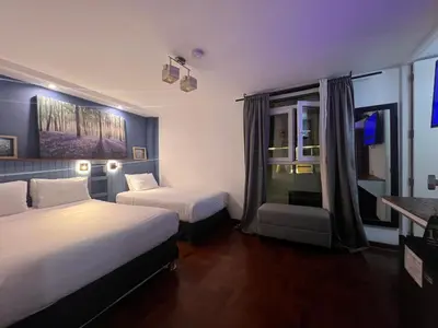 a hotel room with two beds and a window at La Casa del Viajero in Lima