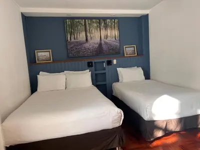 two beds in a room with blue walls at La Casa del Viajero in Lima