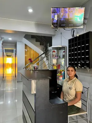 a woman sitting at a counter in a kitchen at Hotel AK7 in Nazca