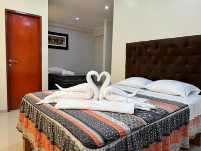 two swans are sitting on top of a bed at Hotel AK7 in Nazca