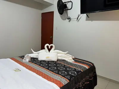 a bedroom with a bed with two stuffed animals on it at Hotel AK7 in Nazca