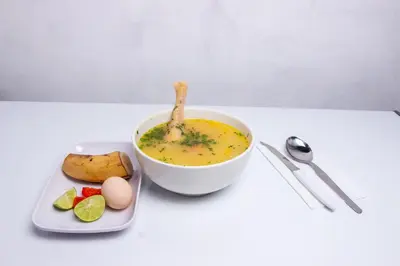 a bowl of soup and a plate of food on a table at Hospedaje EL EDEN DE DON AYDEN in Satipo