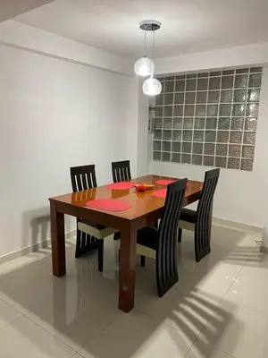 a dining room table with four chairs and aendant light at Beautiful Complete Apartment in Lima
