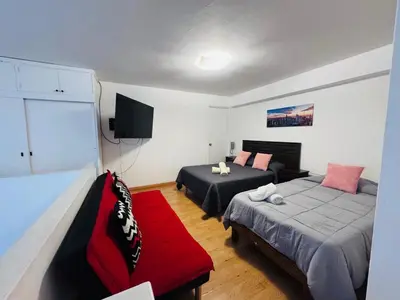 a bedroom with two beds and a couch and a television at Monterrico Polo Aparts 6 - DPTO CON 3 CAMAS FRENTE EMBAJADA USA in Lima