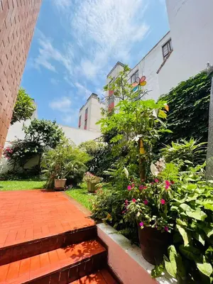 a garden with plants and flowers in front of a building at Monterrico Polo Aparts 6 - DPTO CON 3 CAMAS FRENTE EMBAJADA USA in Lima