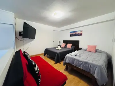 a bedroom with two beds and a red rug at Monterrico Polo Aparts 6 - DPTO CON 3 CAMAS FRENTE EMBAJADA USA in Lima