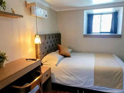 a bedroom with a bed and a desk and a window at Apartamento Céntrico in Cusco