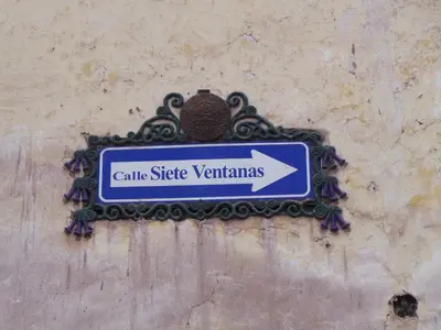 a sign on the side of a wall with an arrow at Apartamento Céntrico in Cusco