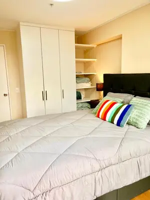 a bedroom with a large bed with white cabinets at Tu refugio en Lima, moderno y céntrico in Lima
