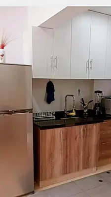a kitchen with white cabinets and a stainless steel refrigerator at Departamento 1 dormitorio San Miguel-Reservas con 1 día de anticipación in Lima