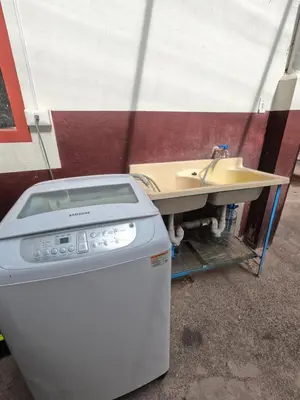 a sink and a washing machine next to a table at Mirador Ernesto Gunter in Cusco