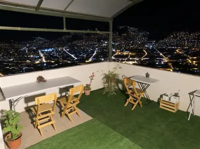 a table and chairs on a balcony at night at Mirador Ernesto Gunter in Cusco