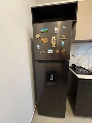 a black refrigerator in a kitchen with stickers on it at Premium apartment in Miraflores with rooftop pool in Lima