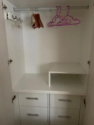 a white closet with white cabinets and a hanger at Hermoso apartamento cerca al estadio San Marcos y el Aeropuerto in Lima