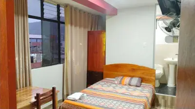 a small bedroom with a bed and a window at Hospedaje El Sureño in Satipo